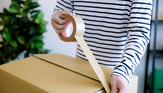 宅配買取で洋服を梱包する女性